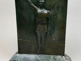 bronze sculpture of a woman holding a bird on a marble base