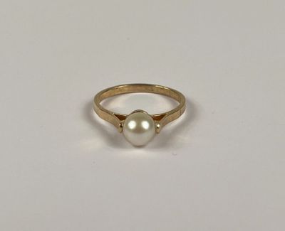 Gros plan sur une bague ornée d'une perle
