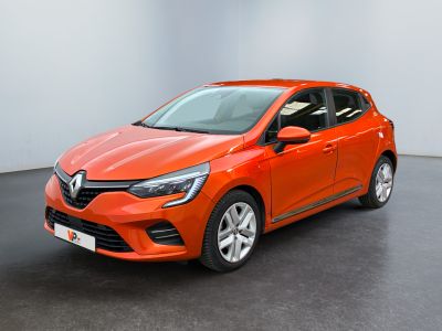 La voiture orange est garée dans une pièce aux murs blancs.