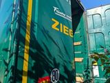 a green and yellow semi truck parked on the side of the road