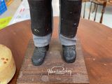 a figurine of a man standing on top of a wooden table