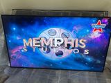 un téléviseur portant l'inscription « Memphis Studios », posé sur un lit