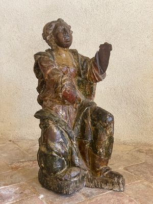 une statue représentant une femme assise sur une chaise