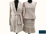 deux mannequins vêtus de vêtements blancs et beiges, posés sur un socle