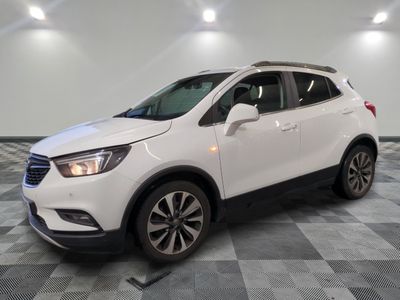 un SUV Buick blanc garé sur un sol à damier dans un garage