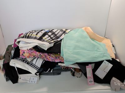 a pile of clothes sitting on a shelf in a closet