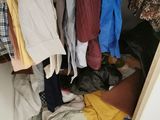 a closet full of clothes and clothes hanging on the wall