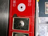 a red vending machine with a clock on it in a kitchen