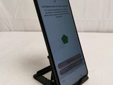 a close up of a cell phone on a stand on a bed