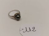 gros plan d'une bague sur une surface blanche avec une étiquette de prix