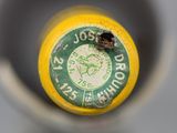 a close up of a yellow bottle with a green label on it