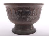 a metal bowl with a design on it on a white surface