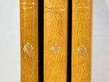 three wooden books sitting on top of each other on a white surface