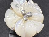une bague en forme de fleur blanche avec une perle au centre