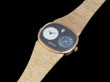 a gold watch with a black face on a black background