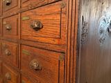 an old wooden dresser with many drawers and knobs