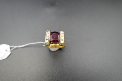 gros plan d'une bague en or avec une pierre rouge