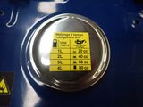 a close up of a blue gas tank with a yellow sticker on it