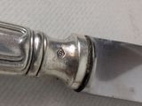 a silver knife with a silver handle on a table