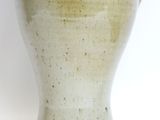a white vase with a handle sitting on a table