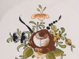 a plate with a bird and flowers on it