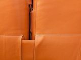 two brown leather chairs sitting next to each other in a room