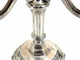 a silver candle that is on a stand on a white background