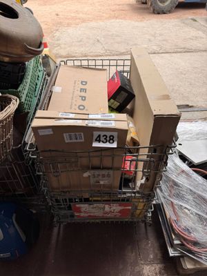 un chariot rempli de cartons et d'autres objets, posé par terre