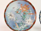 two plates with flowers painted on them on a table
