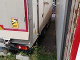 a truck that is sitting in the grass next to a building
