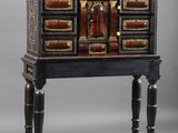 an image of a black and gold chest of drawers on a stand