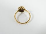 a close up of a gold ring with a brown stone