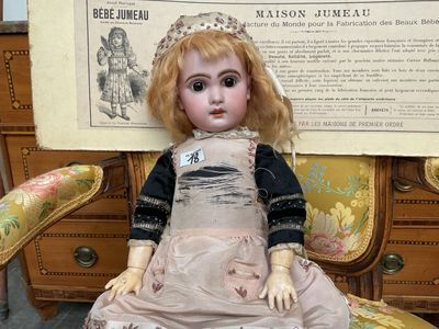 a doll that is sitting on a chair in front of a poster