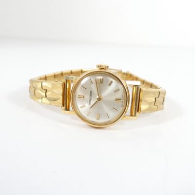 une image d'une montre-bracelet de femme sur une surface blanche