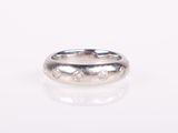 a close up of a silver ring with diamonds on a white surface