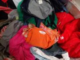 a pile of clothes in a suitcase on the floor