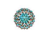 un gros plan d'une broche en pierre turquoise sur fond blanc