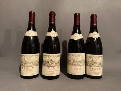 four bottles of wine are lined up on a table