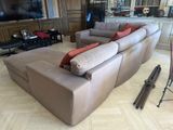 a living room with a large couch and a television on the wall