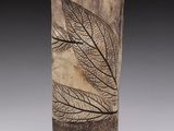 an image of a tall vase with a leaf design on it