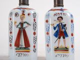 pair of hand painted glass salt and pepper shakers with a lady and man on them