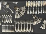 de nombreuses cuillères et fourchettes disposées sur une table