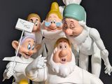 figurines of a group of seven dwarfs with a sign in their hands