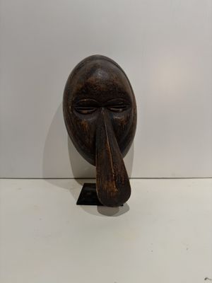 wooden sculpture of a man ' s face with a long nose