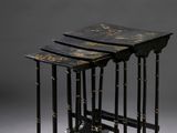 trois tables gigognes noires et dorées sur fond gris