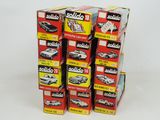 a stack of six boxes of assorted cars on a white surface