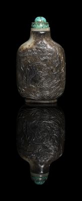 a glass bottle with a green lid sitting on a black surface