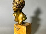 a bronze busturine of a woman on a marble base