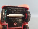 someone is holding a red toy truck with wheels on it ' s side