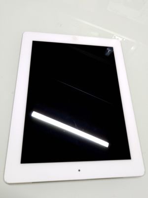 une tablette blanche posée sur une table, sur fond noir